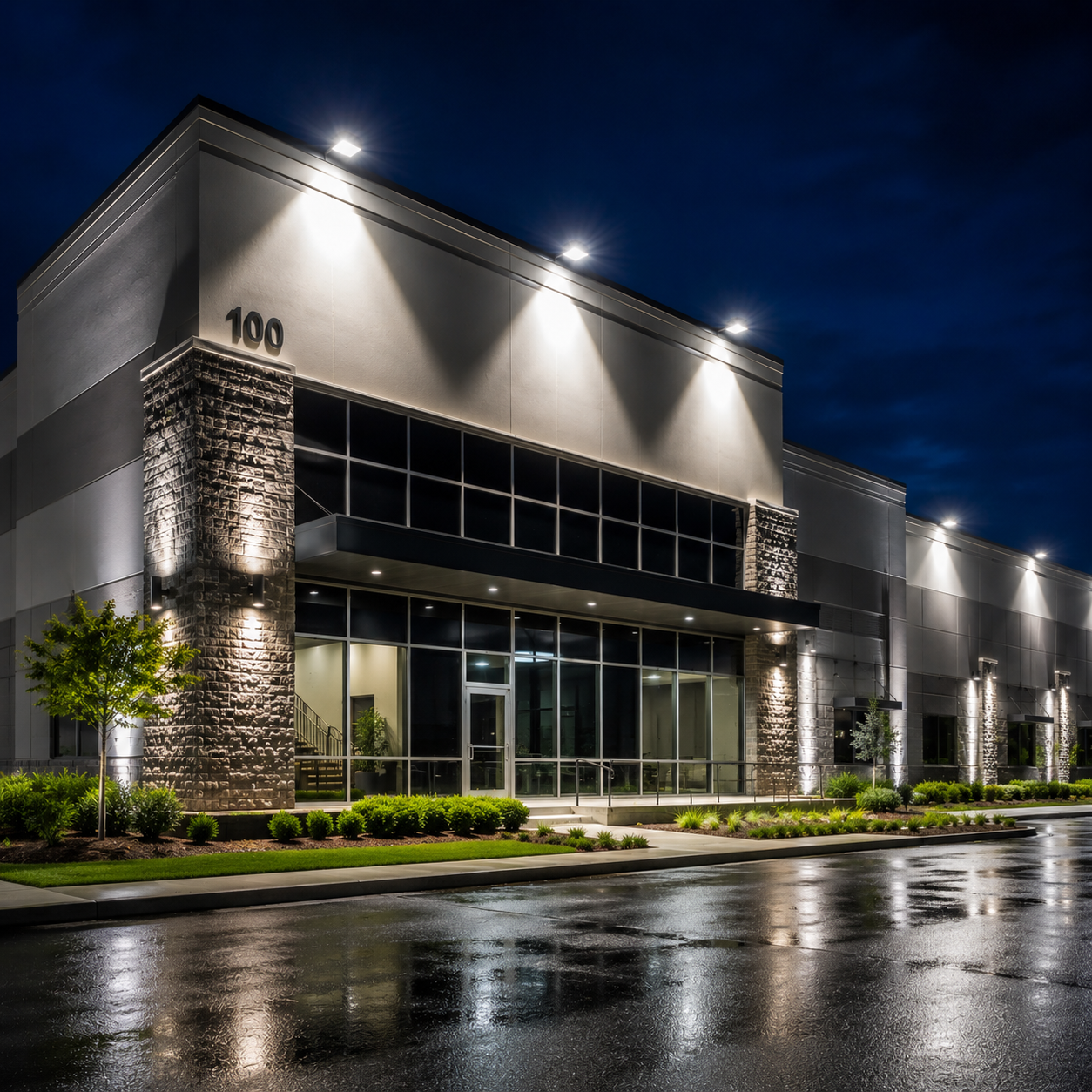 Commercial LED flood lights illuminating a modern building facade with architectural accent lighting, wall-mounted fixtures, and uniform exterior light distribution for commercial properties.
